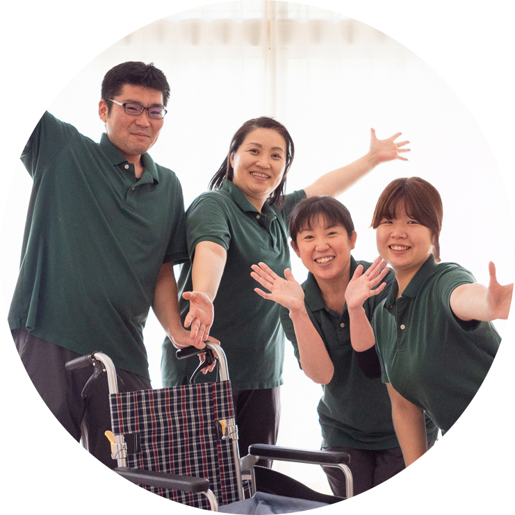 手を広げて笑っている4人の介護職員